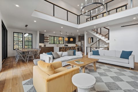 Soaring ceilings, a sleek fireplace, and walls of windows create a bright, inviting living space with serene treetop views—perfect for gathering and unwinding year-round.