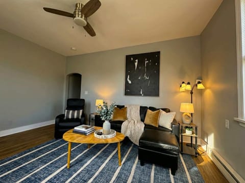 Living area with sofa seating, accent chair, ceiling fan, TV, and coffee table.