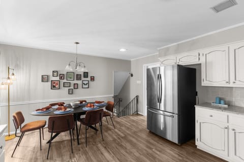 Dining area with 8 seats and chandelier, nearby the kitchen