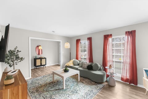 Living room with windows, plush couch, and airy ambience