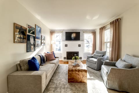 Living room with plush and large couch, with fireplace and tv mounted above