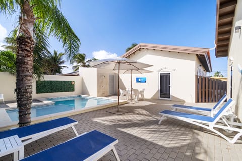 Luxury pool area of the apartment in Noord Aruba - Lush and refreshing environment - Cozy beach chairs available - Beautifully sunbathed space makes the soul peaceful - Experience the comfort at the best