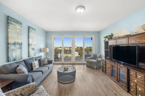 Relax in this coastal-inspired living room with natural light and balcony views.