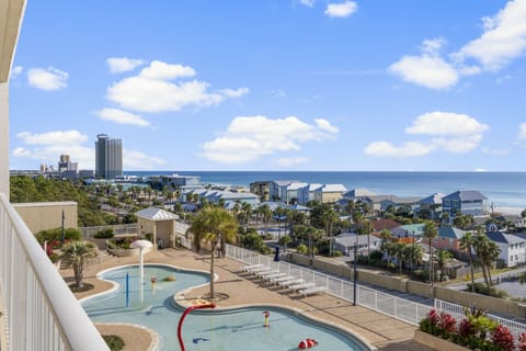 Ocean view from the balcony overlooking the pool and nearby beach houses.
