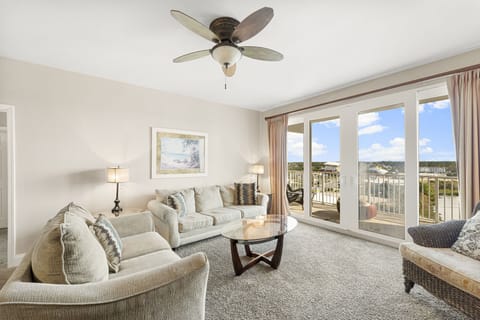 Relax in this bright living room with balcony access and scenic views.