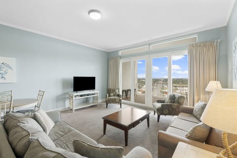 Spacious living room with large windows offering city views and natural light