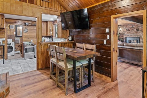 Dining and lounging area with huge 65" TV close to the kitchen.