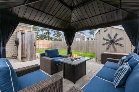 Awesome fenced-in backyard with ample grass space, and outdoor shower, oversized new patio and premium metal gazebo with thick cushioned outdoor seating and a fire pit table, and of course a grill.