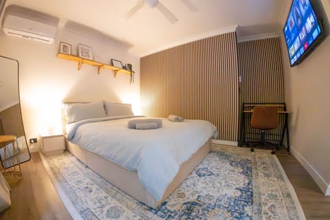air conditioned studio with desk, full length mirror, tv and queen bed