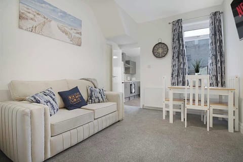 An open-plan living room & dining area equipped with a SMART TV with Netflix and a comfortable sofa to sit down and relax. 