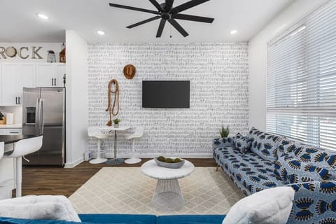 Living room with two comfy couches, a ceiling fan, and a Smart TV with all the streaming apps. Bonus high-top table with seating for 2.