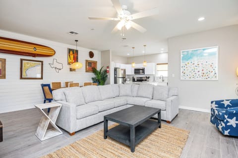 Relax in your spacious living room featuring coastal decor and an open layout flowing into the fully equipped kitchen.