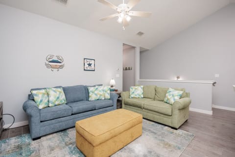 Relax in your bright living space with coastal charm, where comfortable seating and soothing colors create the perfect spot to unwind.