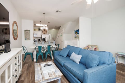 Settle into your bright, coastal-themed living space where turquoise chairs and a blue sofa create perfect spots for relaxation and meals together.