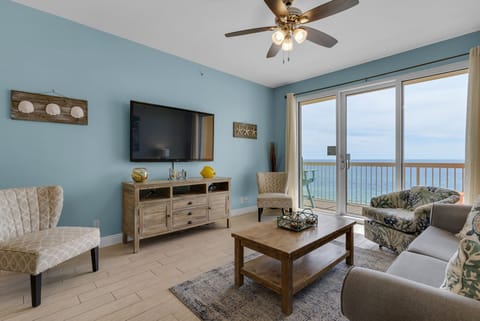 Living Room - Relax in luxury and comfort in this gorgeous living space featuring a large flat-screen TV, coastal decor, and a private balcony with breathtaking beach views.