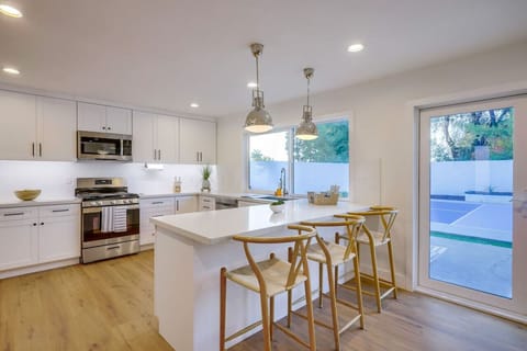 Bright kitchen & dining area w/ island seating and direct access to the pool patio.
