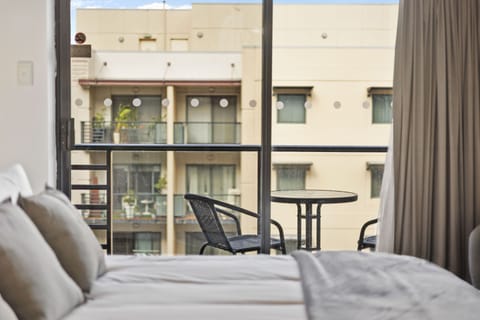 Enjoy breathtaking city views from your private balcony, complete with comfortable seating for relaxing and soaking up the atmosphere.