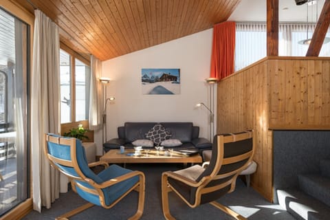 Cosy living area with wooden ceiling and large windows