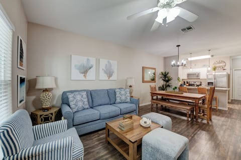 Relax in your coastal-inspired living space with a plush blue sofa and open kitchen perfect for preparing meals together.
