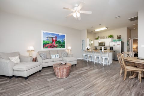 Relax in your spacious open living area with comfortable sectional seating, modern kitchen, and coastal-inspired décor creating the perfect home base.
