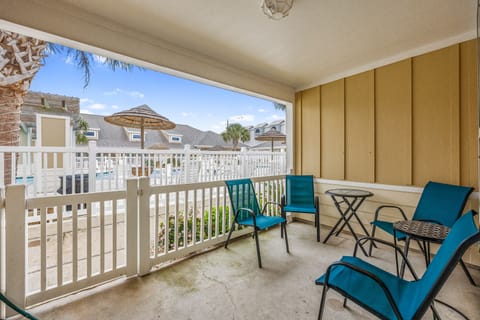 Enjoy your morning coffee on your private balcony, where turquoise chairs invite relaxation while you overlook the resort's tropical atmosphere.