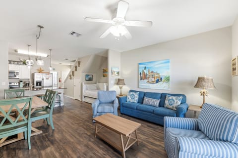 Step into your open-concept retreat where coastal charm meets comfort. Sink into plush blue furnishings, gather around the welcoming dining table, and enjoy the breezy ceiling fan keeping you cool throughout your stay.