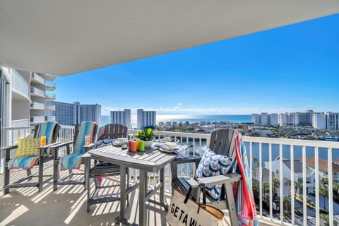 Your private balcony offers stunning coastal views while you dine al fresco at the outdoor table, watching the waves dance beyond the city skyline.