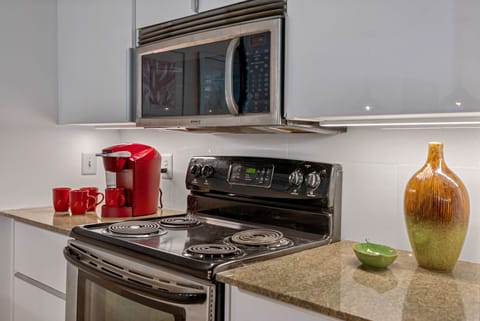 Kuerig coffee maker. Lacquered cabinetry. Elegant glass tiled backsplash.  
