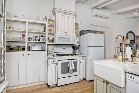 Kitchen view, with gas stove. Lots of dishes.