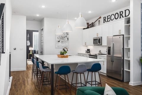 Huge kitchen on the main floor of the house with a massive island, seating for 9, and all the appliances / supplies you'd need to cook a meal.