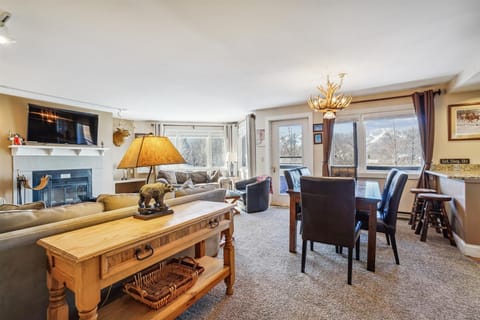 Bright and inviting living area with large windows, comfortable seating, and scenic mountain views.