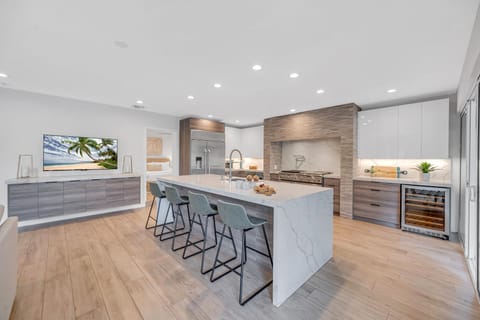 The gourmet kitchen opens on the living room featuring incredible views of the tropical landscape.