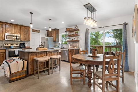 Open concept dining area. 6 chairs (4 shown) plus two counter stools