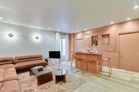 Salon avec cuisine américaine et table haute pour diner