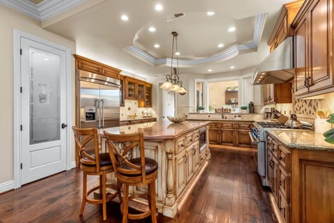 Fully stocked kitchen with high end appliances and large kitchen island with two barstools.