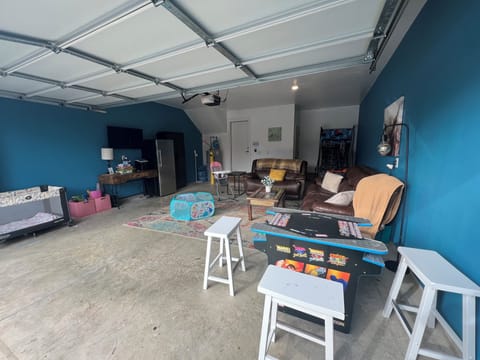 GAME ROOM - Step into our ultimate garage arcade! With a cocktail table game machine, TV, refrigerator, and comfy sofa, your stay promises non-stop fun and relaxation. Welcome to your entertainment paradise