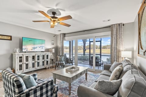 Bright, beautifully furnished living area with scenic lake views and direct patio access—perfect for relaxing coastal mornings and sunsets.