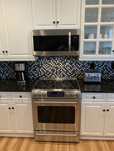 Kitchen featuring stainless steel GE Cafe stove and Samsung microwave
