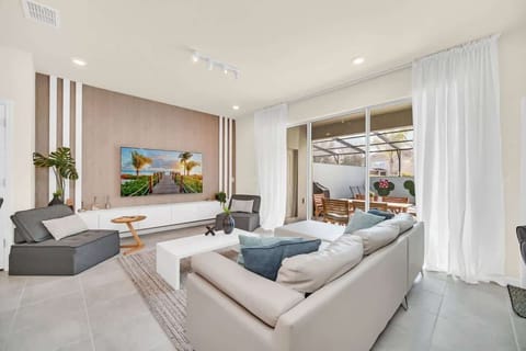 Modern living room with large windows opening to a private outdoor dining area.