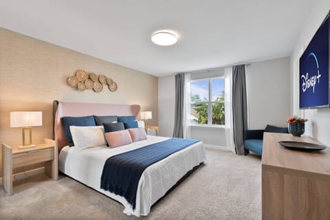 Experience a cheerful and airy bedroom with a plush queen bed, soft linens, modern side tables, and stylish lamps. The light-colored walls and large window make it an ideal retreat for relaxation and unwinding.