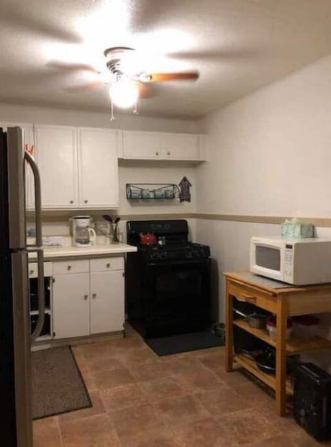 Counter and gas stove, microwave, and storage for pots and pans.