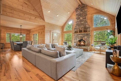 Unwind in this cozy living room with a warm stone fireplace and plush seating – perfect for family movie nights or quiet evenings in.