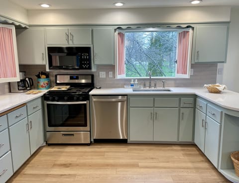 The large kitchen is stocked with ample flatware and dishes to serve a crowd.