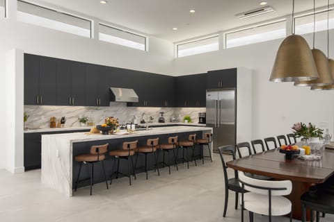 Gourmet fully-equipped kitchen with a full suite of appliances and barstool seating that opens into the dining area.