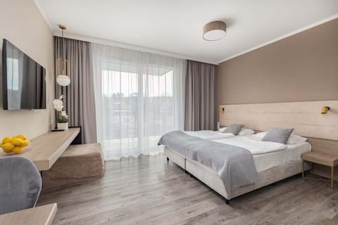 Bedroom with double bed, soft lighting, and beige decor for a calming atmosphere.
