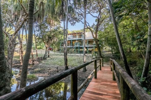 Exterior with rainforest surrounds, teal railings, and wooden walkway. Family‑friendly property with spacious outdoor living and private access.
