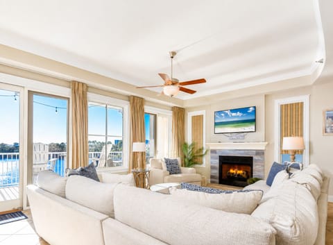Unwind in your bright living room with plush seating, cozy fireplace, and gorgeous water views through floor-to-ceiling windows.