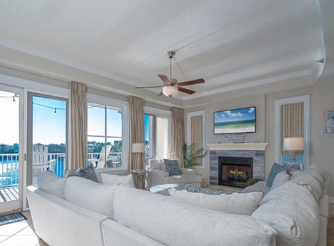 Unwind in your bright living room with plush seating, cozy fireplace, and gorgeous water views through floor-to-ceiling windows.