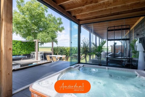 Relax in the covered jacuzzi with panoramic countryside views. Enjoy this private wellness space in every season, just steps from the sauna, cocktail bar, and outdoor lounge for the ultimate group getaway. 