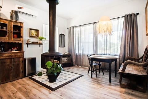 Cozy dining nook with natural light, stylish accents, and a decorative vintage stove centerpiece.